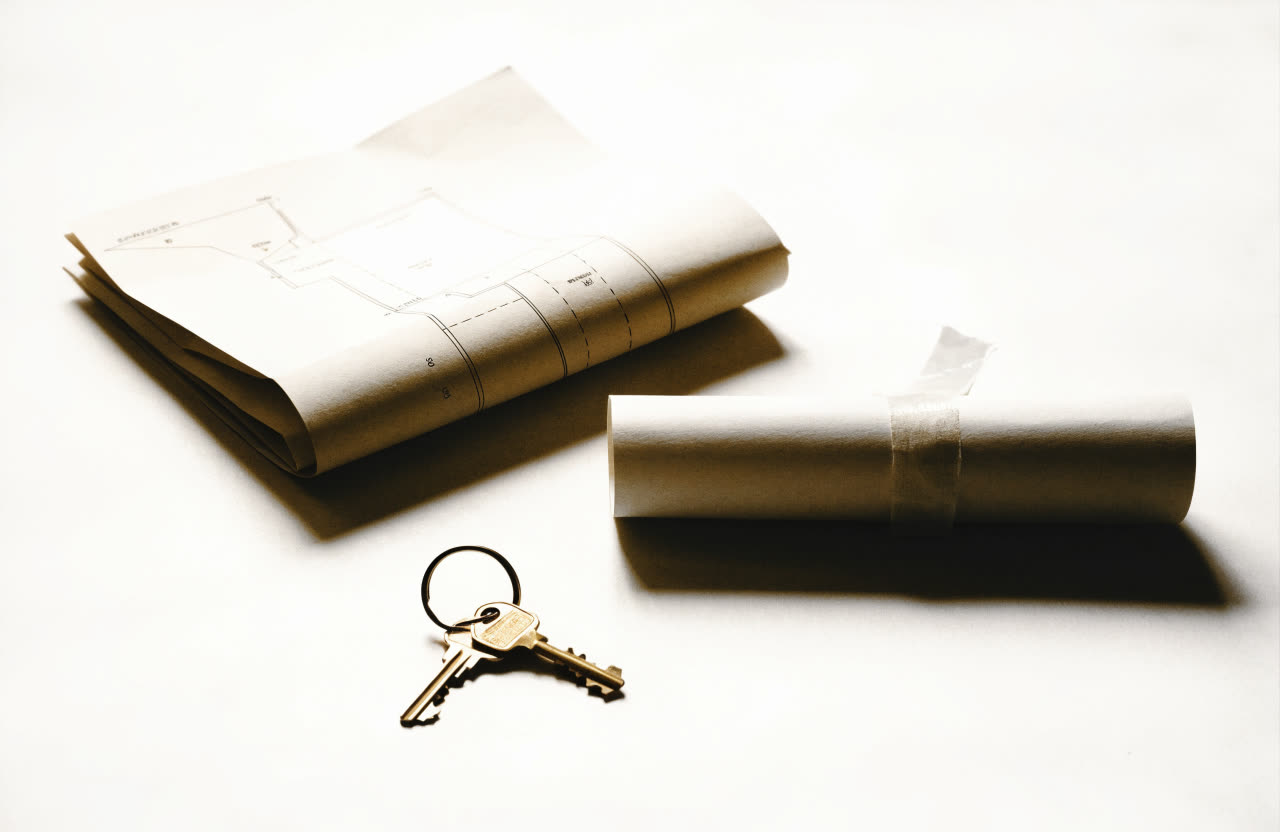A folded land survey plan, a rolled deed and two keys